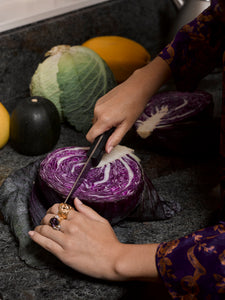 Model cutting into a cabbage wearing various rings